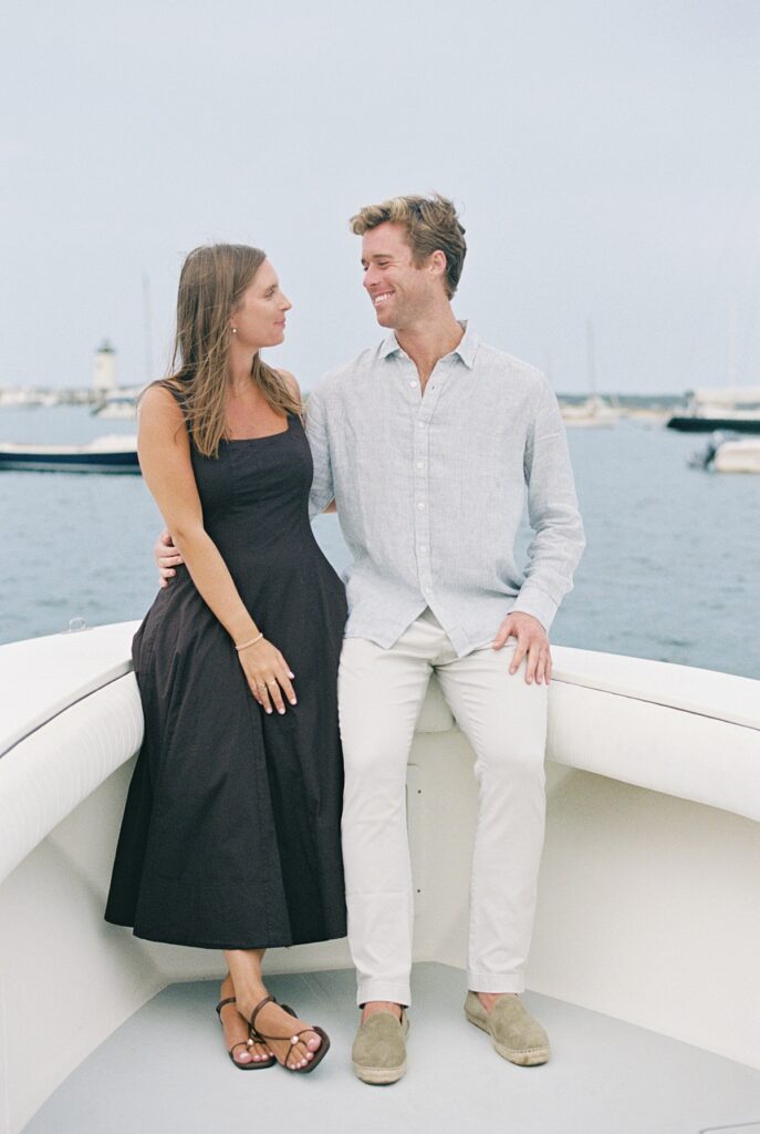 Engagement portraits on a boat with Edgartown harbor in the background