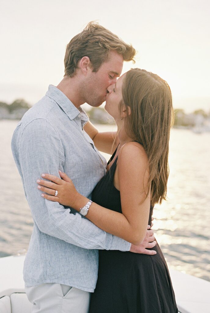 Engagement portraits on a boat with Edgartown harbor in the background